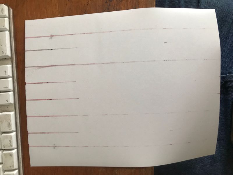 The reverse of the paper, showing the ink streaks that are being printed instead of 80% of the design on the correct side.