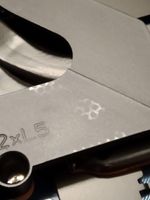 not dust, as running my finger over top of this doesn't remove it, and it feels a bit bumpy. Also, notice the "L5" is a bit less embossed than the "2x" is.... possibly also due to the heating.