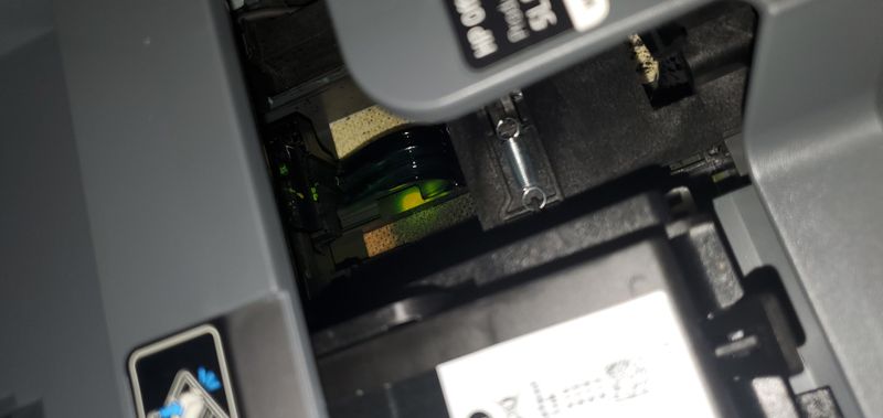 Inside printer, next to black ink cartridge